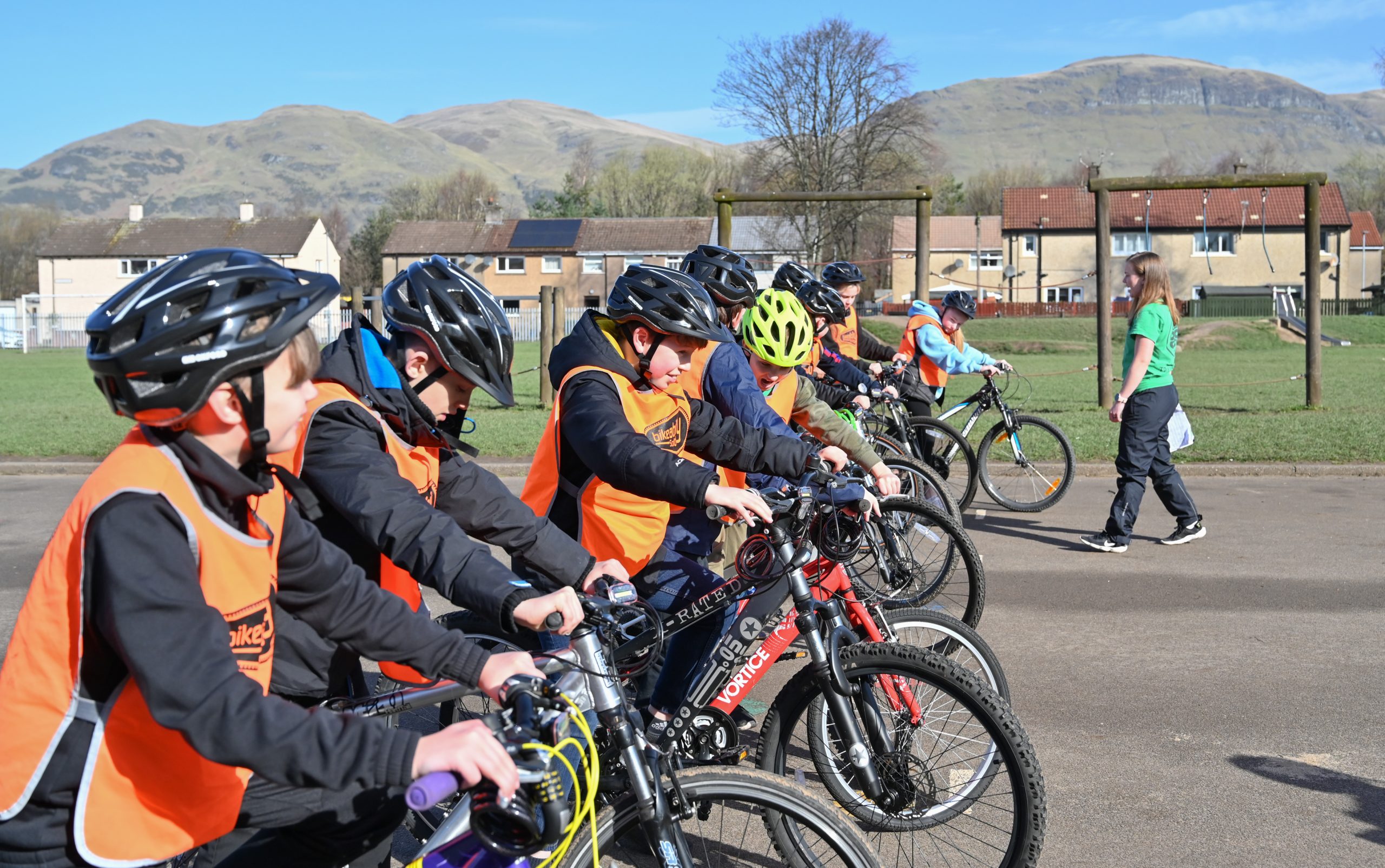 A group of children standing with their bikes and ready to start cycling, on a bright day.