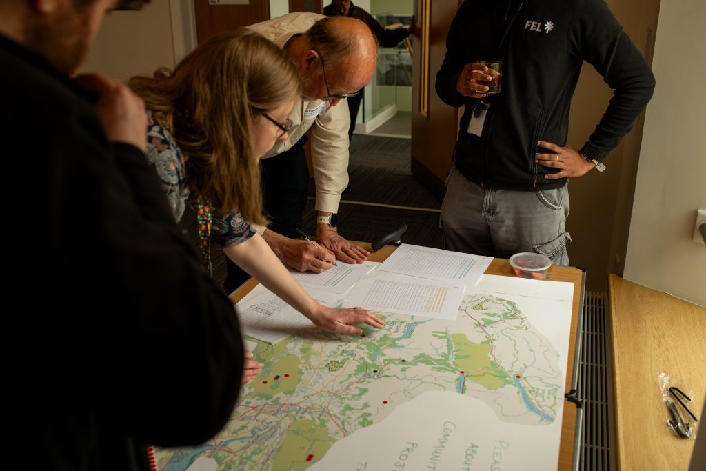 Four people standing around a map of community energy projects